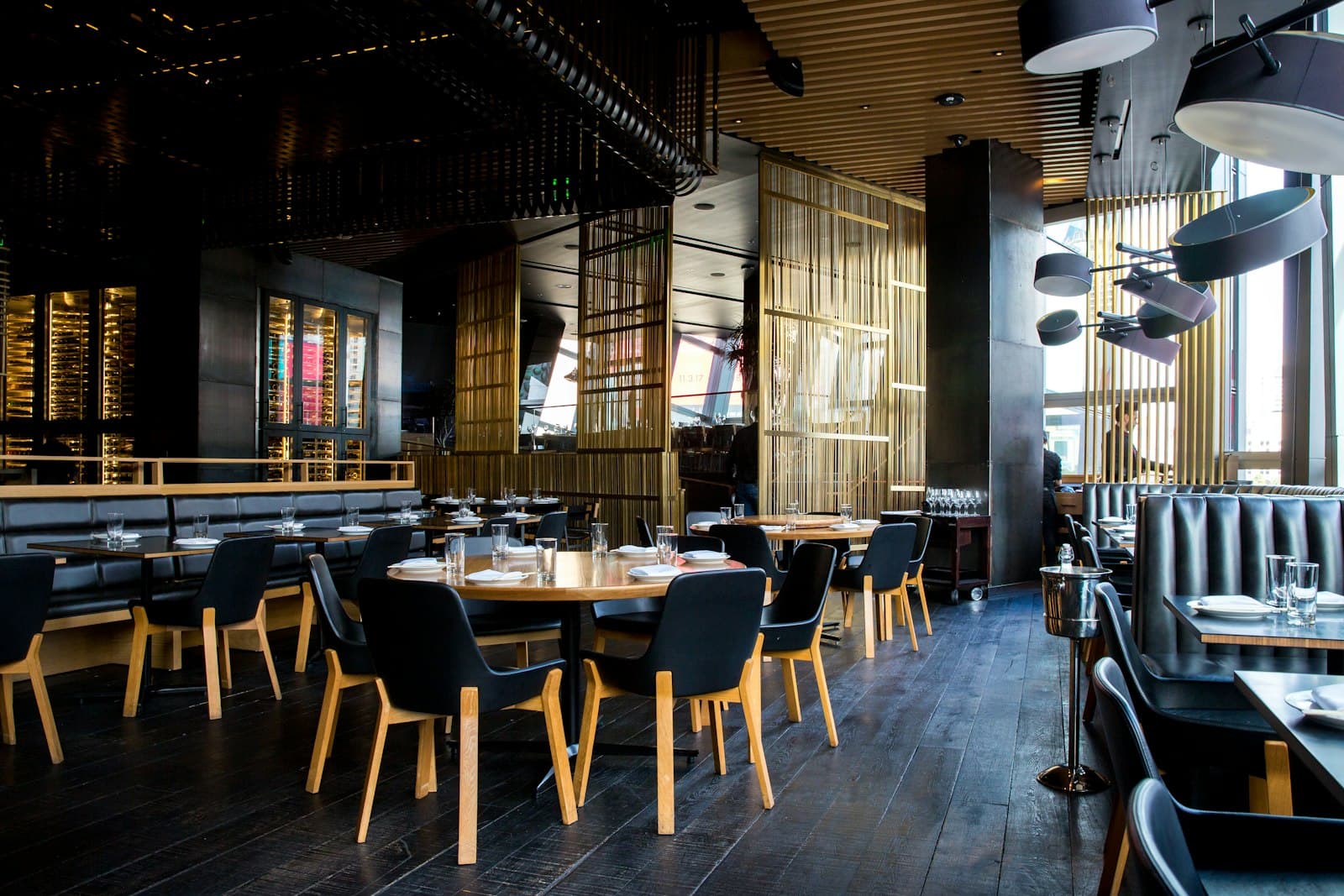 Salão de restaurante japonês com madeira escura e divisórias douradas